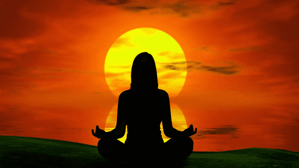 An annoyingly serene silhouette of a woman in a meditative pose against a sunset